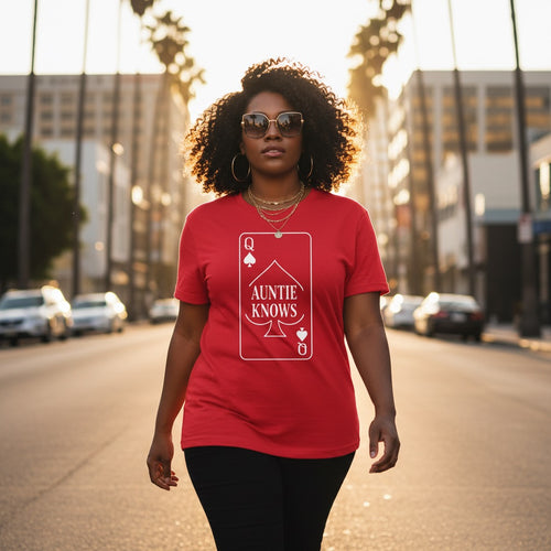 Woman wearing a red t-shirt with 'Auntie Knows' design on a city street.