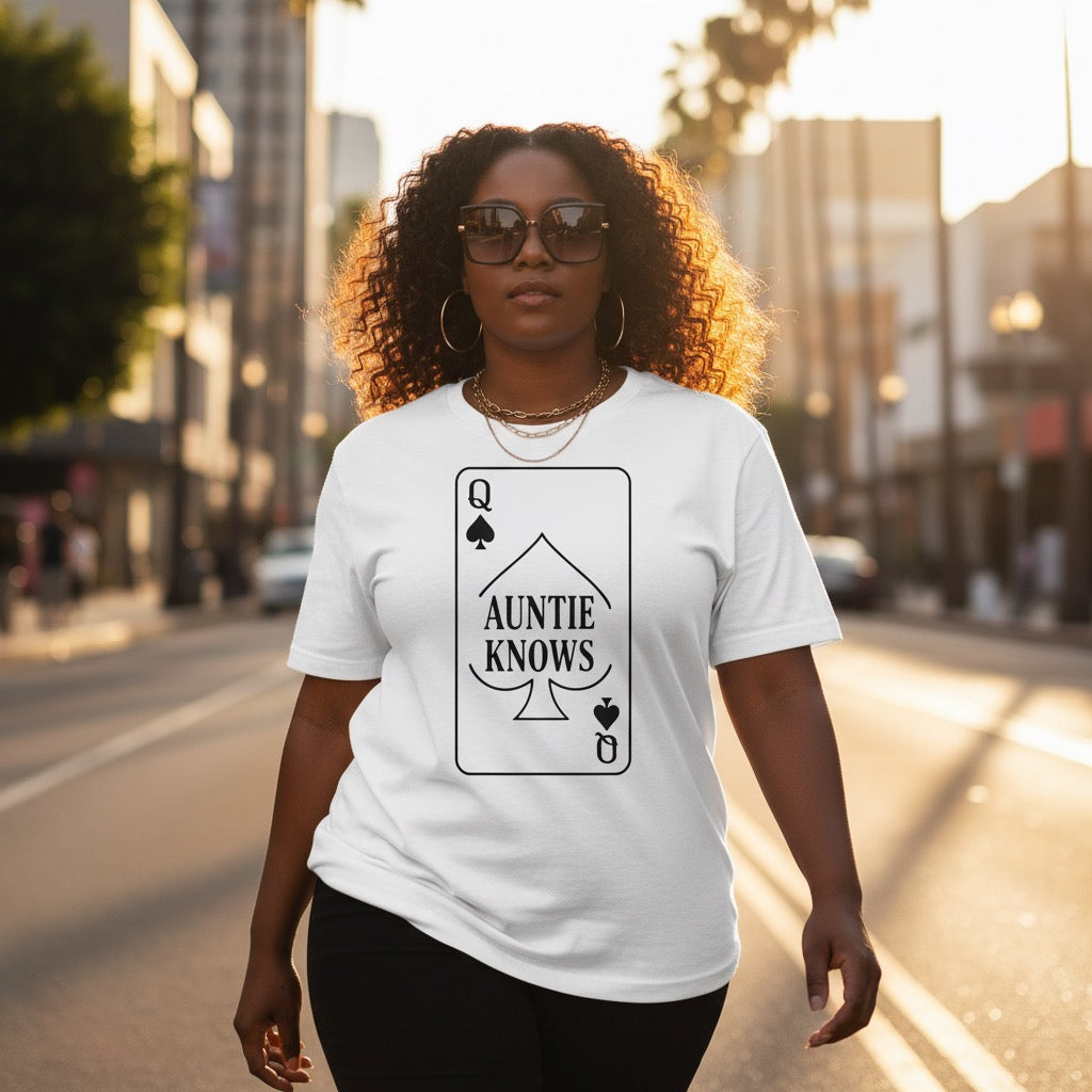 Woman wearing a white t-shirt with 'Auntie Knows' design on a city street.