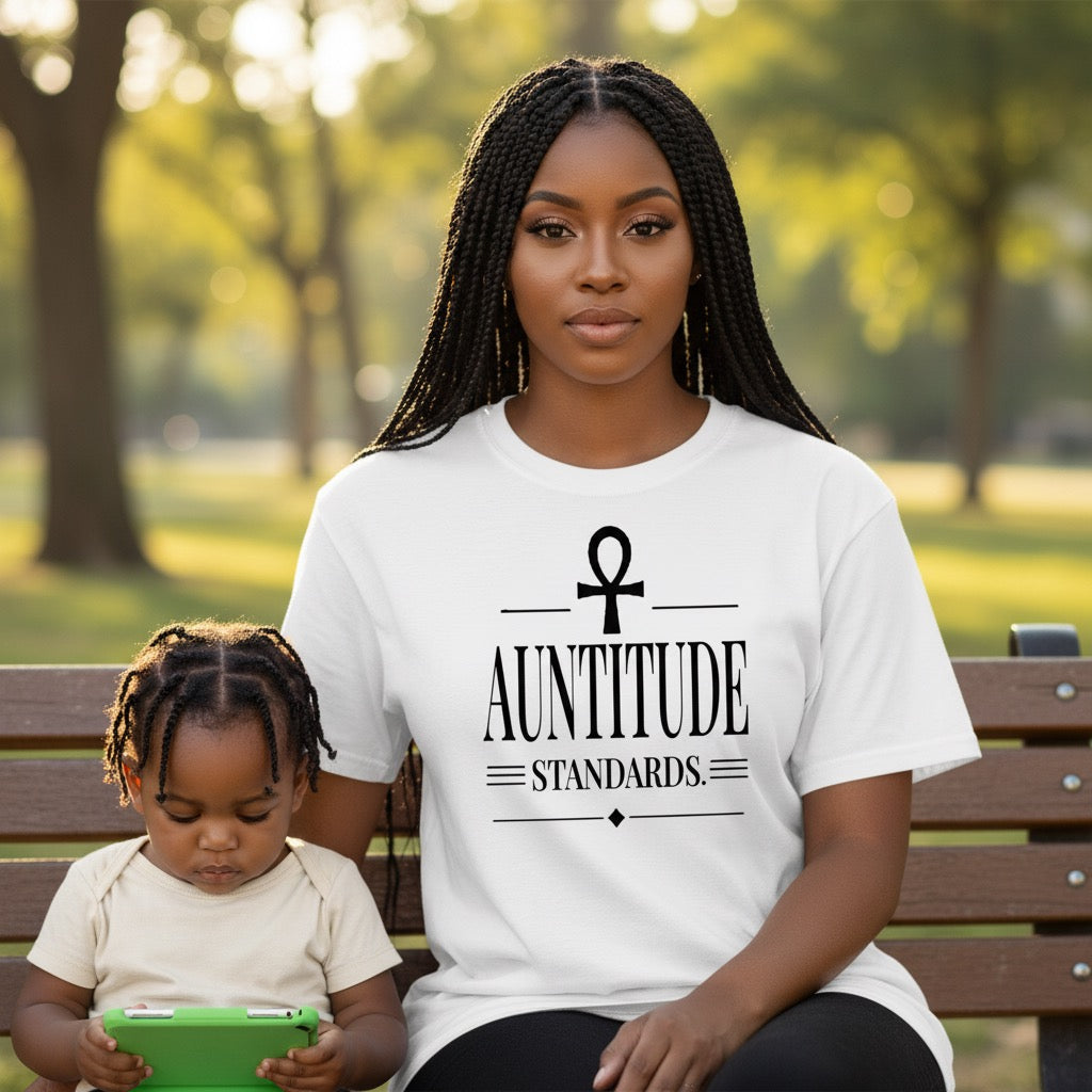 Woman and child sitting on a park bench with a woman wearing a 'Auntitude Standards' shirt.