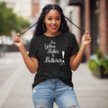 Woman wearing a black t-shirt with 'I'm Getting Better & Betterer!' text, standing on a street.