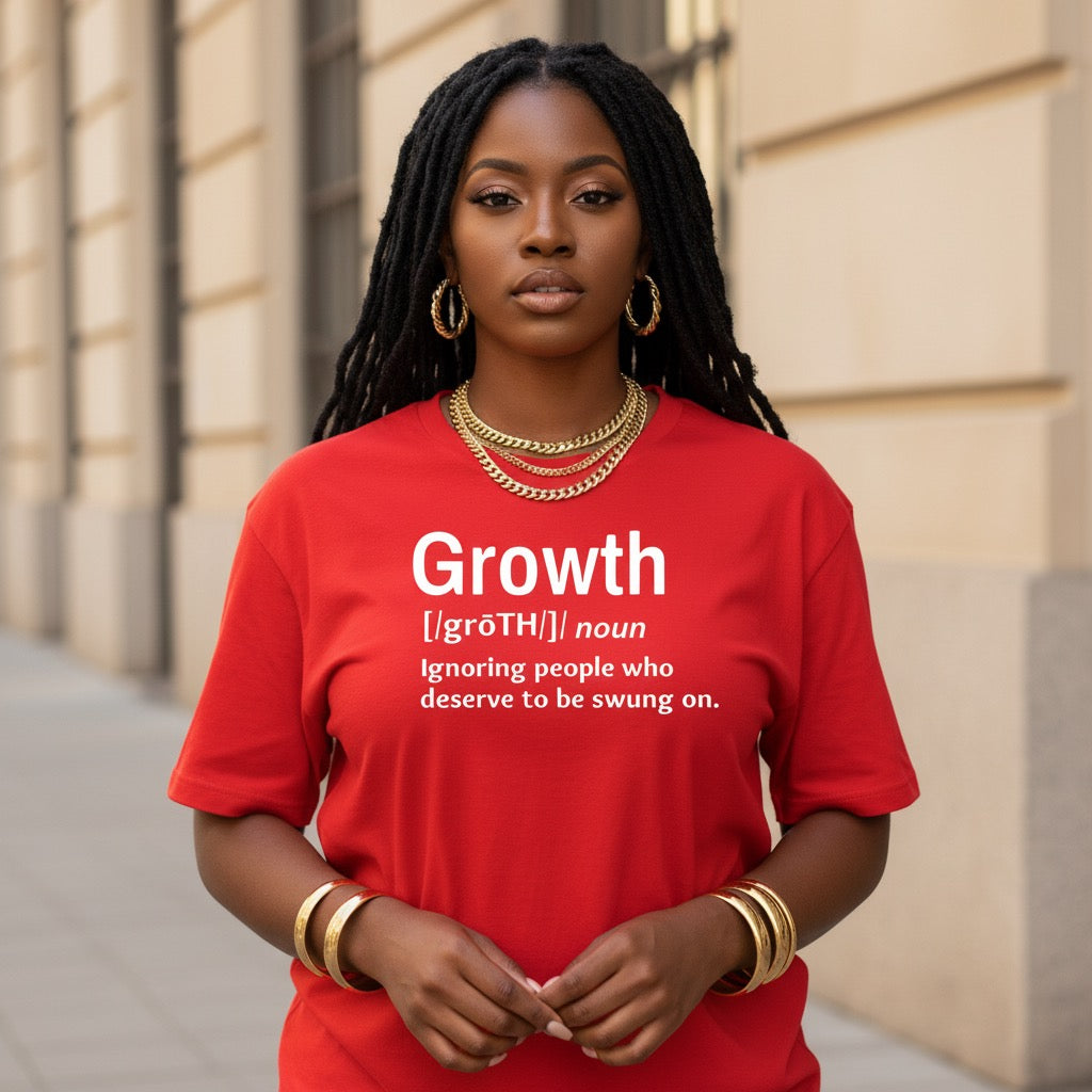 Woman wearing a red t-shirt with a motivational quote on it, standing against a building.