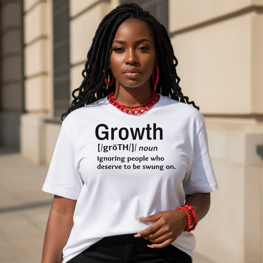 Woman wearing a white t-shirt with a humorous definition of 'growth' printed on it, standing outdoors.