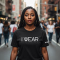 Woman wearing a black t-shirt with 'I WEAR' text on a city street.