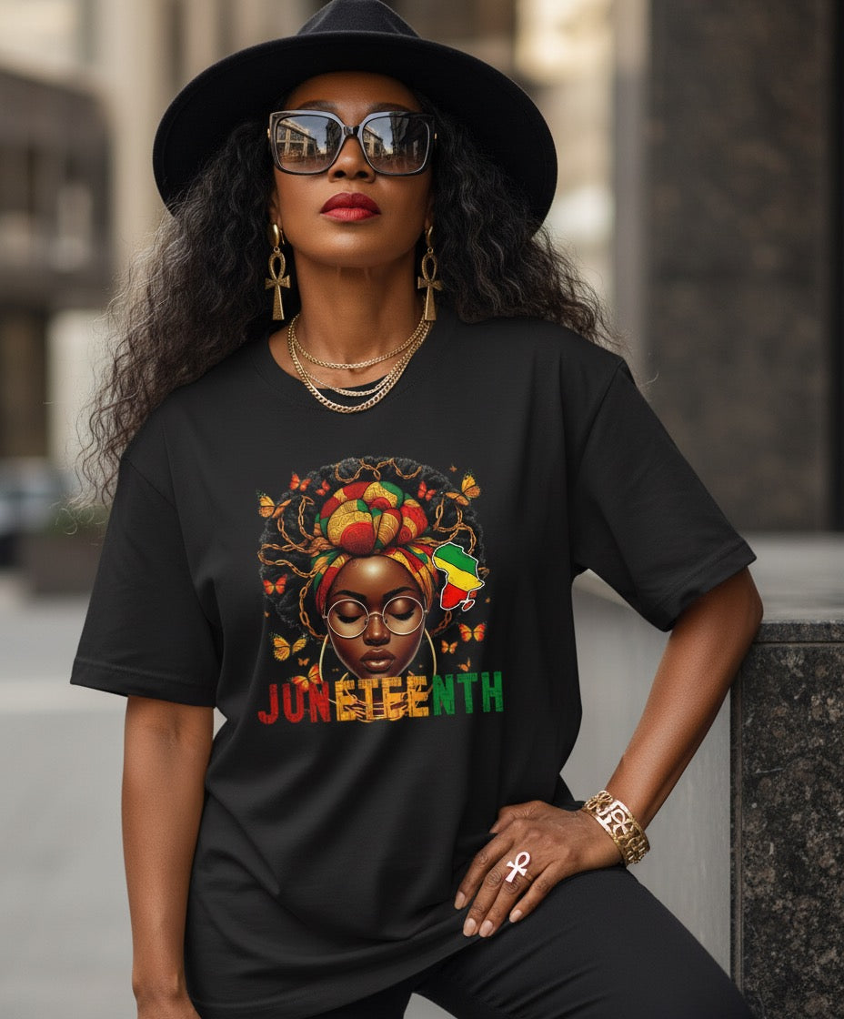 Woman wearing a black t-shirt with a colorful graphic and 'JUNETEENTH' text, sitting outdoors.