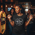 Woman wearing a black t-shirt with text in a bar setting