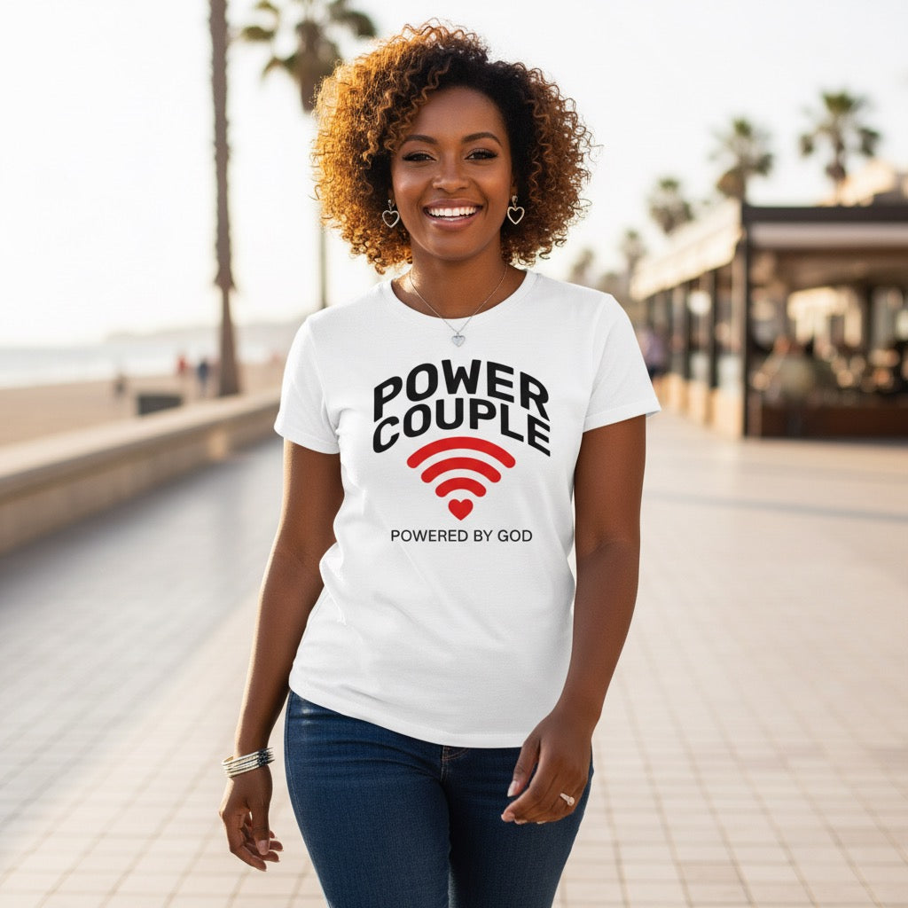 Woman wearing a white t-shirt with 'Power Couple' design, standing on a pathway with palm trees in the background.