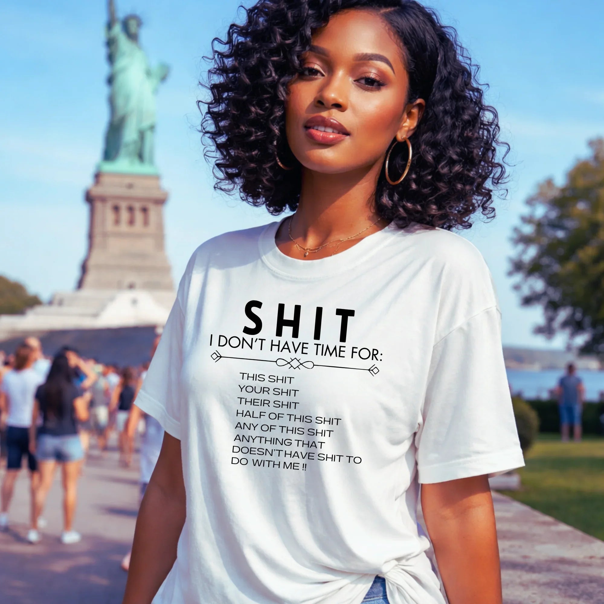 Woman wearing a white t-shirt with text in front of the Statue of Liberty.