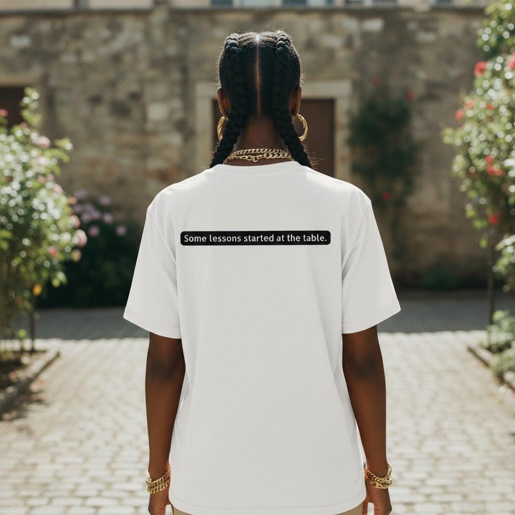 Black woman wearing “Some lessons started at the table” cultural statement apparel by Legacy 4 Xavier
