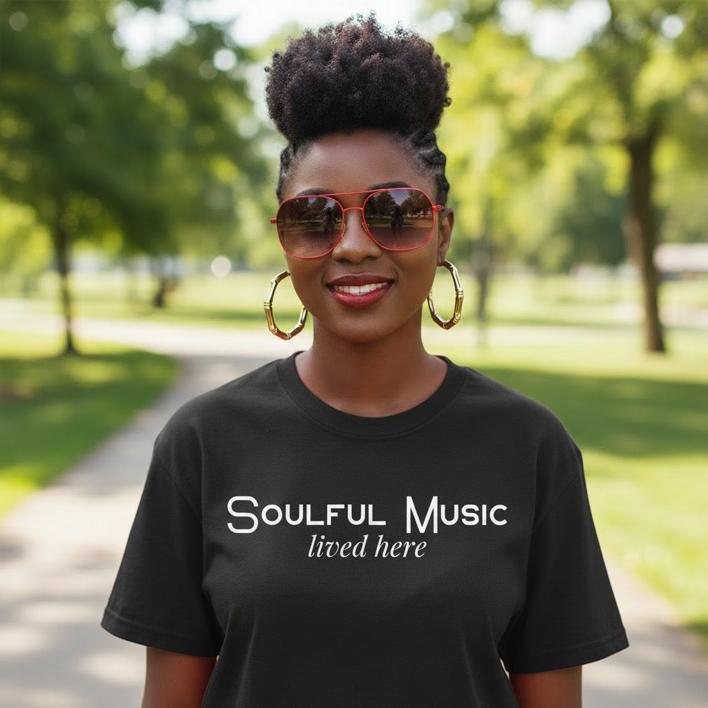 Woman wearing a black t-shirt with 'Soulful Music lived here' text in a park.