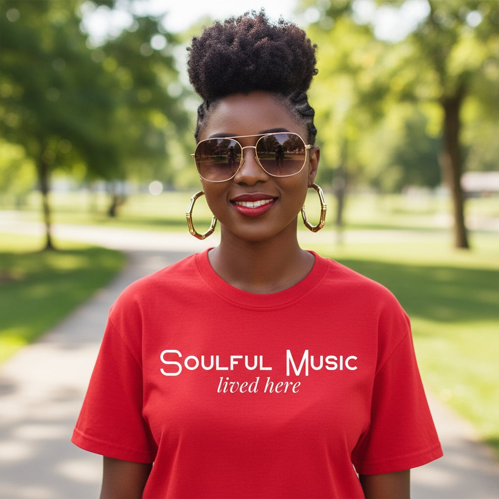 Person wearing a red 'Soulful Music lived here' t-shirt in a park setting