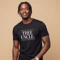 Man wearing a black t-shirt with 'THEE UNCLE.' text on a beige background