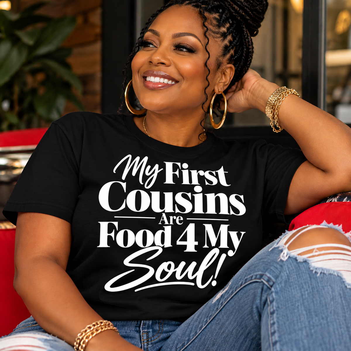 Black woman wearing a black My First Cousins Are Food 4 My Soul graphic T-shirt