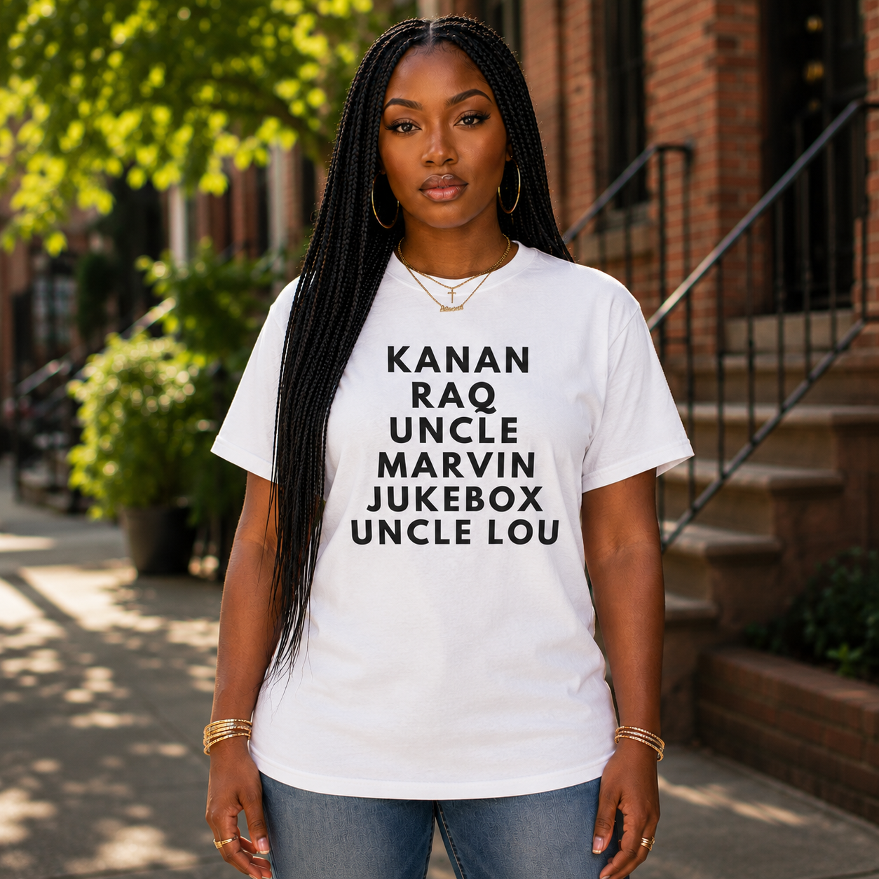 Black woman wearing the Raising Kanan Family Roll Call graphic tee in white with black typography.